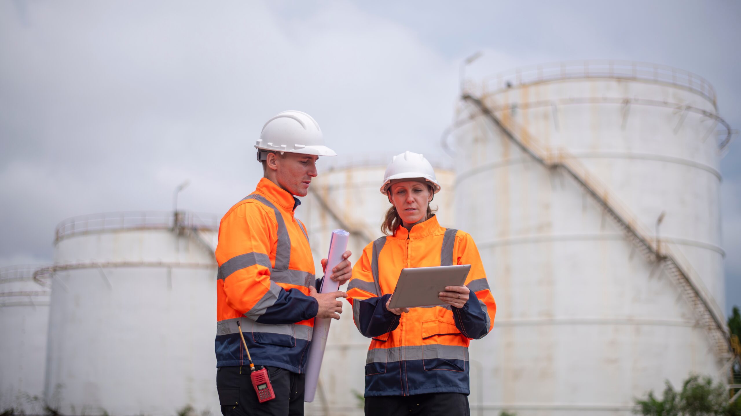 Two workers at a plant reading mustering information.